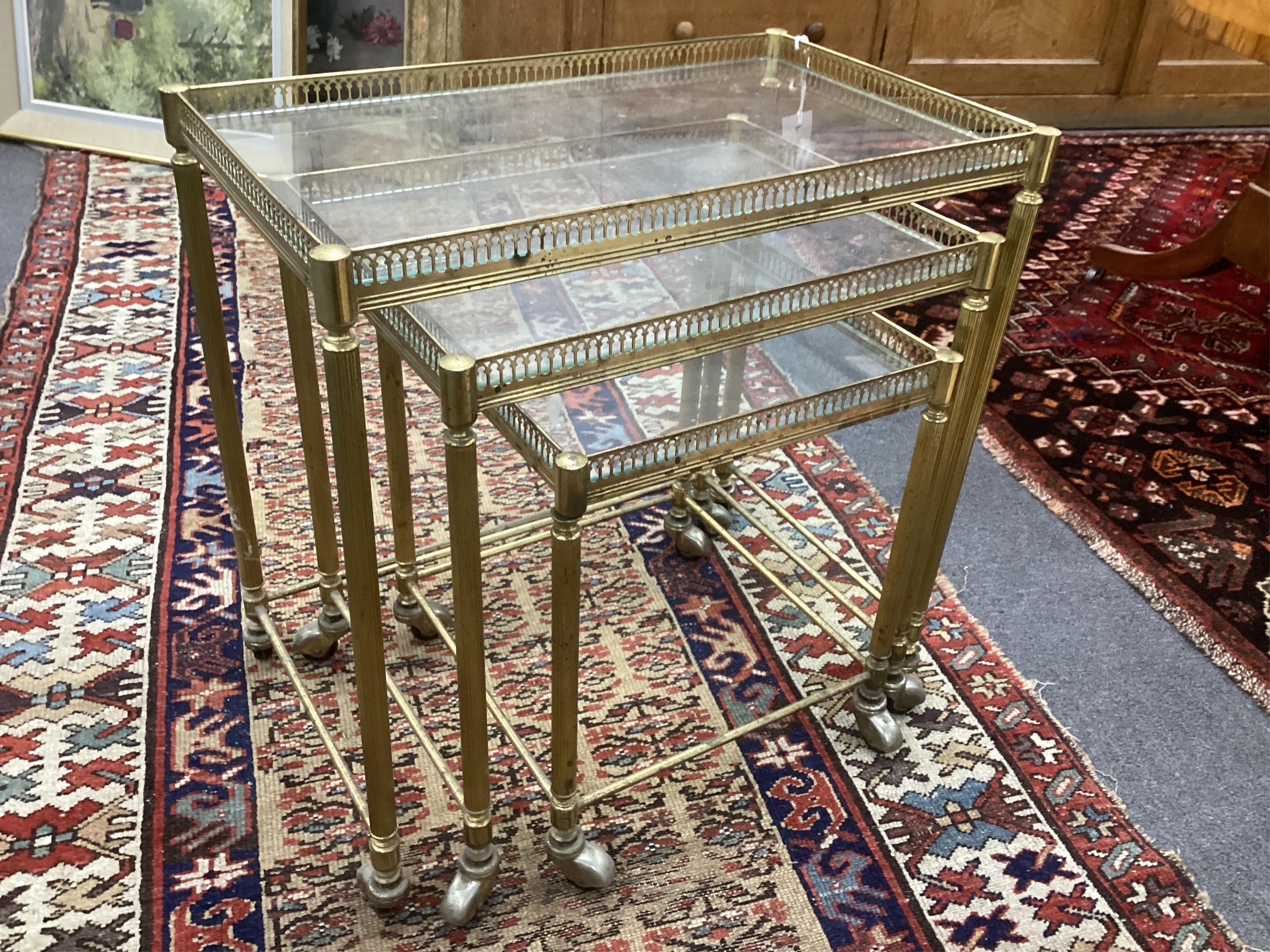 A nest of three mid century brass and glass tea tables, width 52cm, depth 32cm, height 52cm. Condition - fair